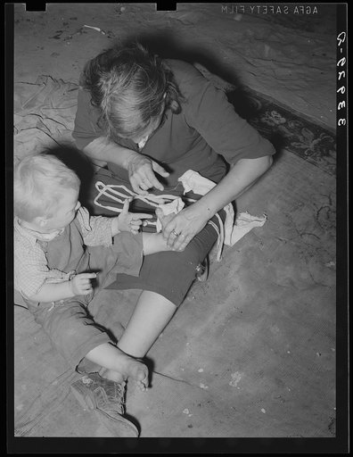 Mother bandaging toe of her son which was cut in debris of Mays Avenue camp. Oklahoma City, Oklahoma
