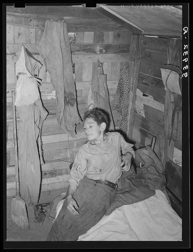 Boy in corner of shack home near Mays Avenue. Oklahoma City, Oklahoma