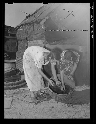 Mother and daughter picking over crawfish which they catch to sell for bait. Mays Avenue camp, Oklahoma City, Oklahoma. Refer general caption 21