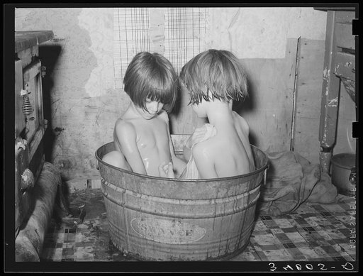 Children taking bath in their home in community camp. Oklahoma City, Oklahoma. See general caption 21