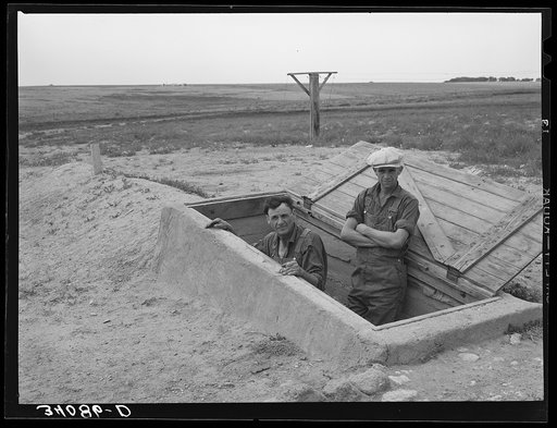 Mr. Shoenfeldt and son, FSA (Farm Security Administration) client in Sheridan County, Kansas, at entrance to fruit cellar which they built for six dollars and twenty cents