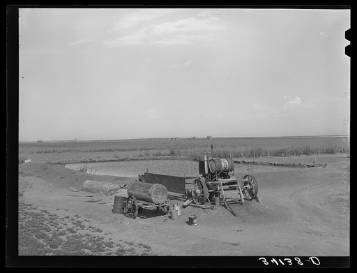 Pumping machinery and irrigation pond at cooperative well on the Davidson farm. Near Cimmaron [i.e. Cimarron], Kansas
