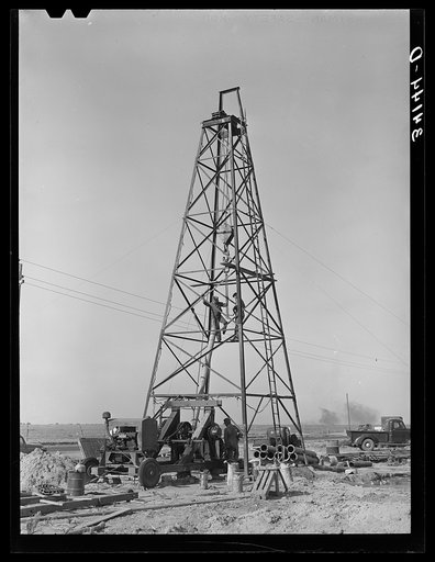 Lifting casing upon the derrick to finish a water well for irrigation purposes on farm near Garden City, Kansas