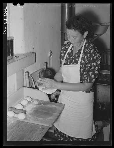 Tortillas being shaped after they have been rolled flat. Spanish-American home near Taos, New Mexico, Taos County