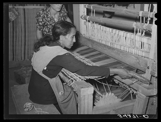 Spanish-American woman passing shuttle through warp in weaving rag rug. WPA (Works Progress Administration/Work Projects Administration) project. Costilla, New Mexico