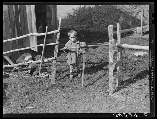 Son of FSA (Farm Security Administration) client going through gate made of old wagon wheel. Farm near Bradford, Vermont, Orange County