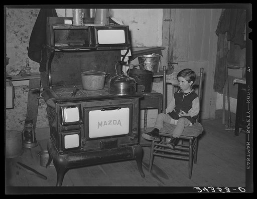 Sitting by the kitchen stove on a cold autumn day in New England. Near Bradford, Vermont, Orange County