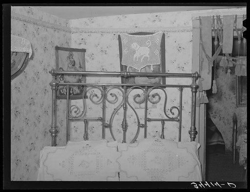Embroidered pillow shams on bed in Spanish-American farm home. Taos County, New Mexico. Notice also the crocheted decorations on top of pictures