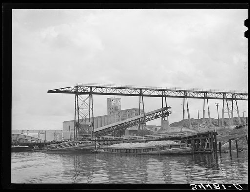 Oyster shell barges at unloading dock of cement plant. Port of Houston, Texas