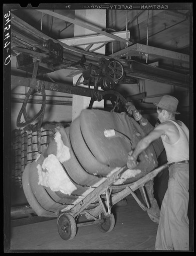 Removing bale of cotton from conveyer. Compress, Houston, Texas