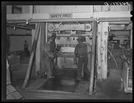 Negro laborers placing bands around compressed bale of cotton. Compress, Houston, Texas