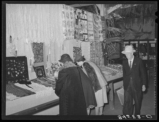Women looking at quilting and crocheting exhibit at Gonzales County Fair. Gonzales, Texas