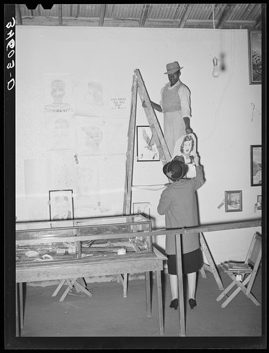 Taking down pictures display in the children's exhibit at the Gonzales County Fair, Texas