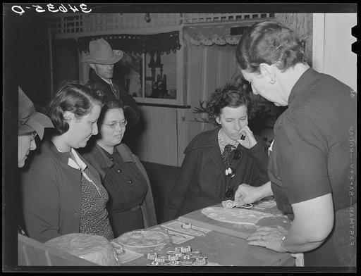 Untitled photo, possibly related to: Farm couple watching the saleswoman demonstrate the use of a gadget at booth at the Gonzales Country Fair, Texas
