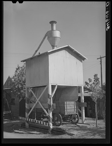 Wagon on scales at feed mill. Taylor, Texas. Ground feed is poured directly into the wagon from the hopper above