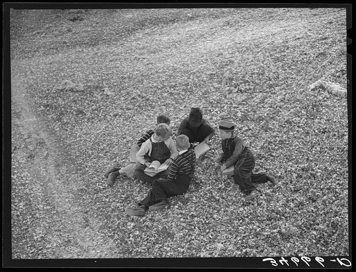 Children playing in the waste in the gin yard on their way home from school. West, Texas