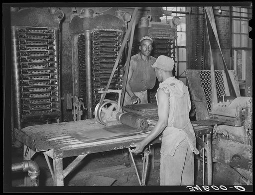 Untitled photo, possibly related to: Workman removing cotton seed cake from mat after oil has been removed. The cake is removed by means of a mandrel machine. Cotton seed oil mill, McLennan County, Texas. The movement of this machine was so fast that it was impossible to stop the action with fastest