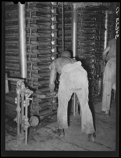 Working on the hydraulic presses at cotton seed mill. McLennan County, Texas
