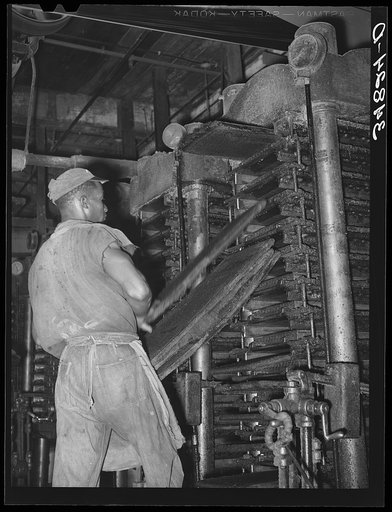 Removing cotton cake from hydraulic presses after oil has been removed. Cotton seed oil mill. McLennan County, Texas