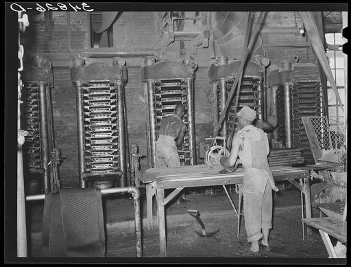 Untitled photo, possibly related to: Removing cotton cake from hydraulic presses after oil has been removed. Cotton seed oil mill. McLennan County, Texas