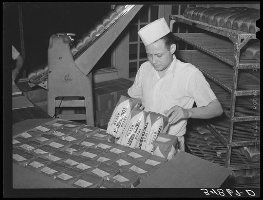 Packing wrapped bread into cartons for easy delivery. Bakery, San Angelo, Texas