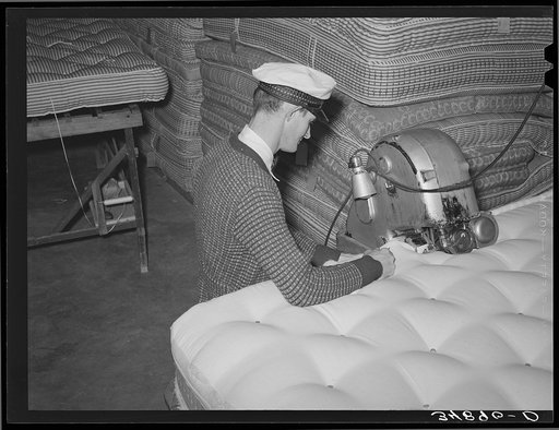 Forming a roll edge on innerspring mattress by special machine. Mattress factory. San Angelo, Texas