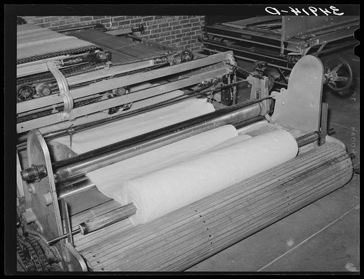 Farming cotton bat on machine in mattress factory. San Angelo, Texas