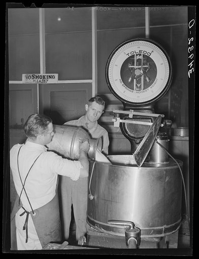 Unloading milk at creamery. San Angelo, Texas. The milk is weighed in this large kettle