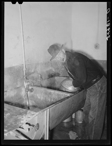 Farmer cleaning out milk can. Creamery, San Angelo, Texas