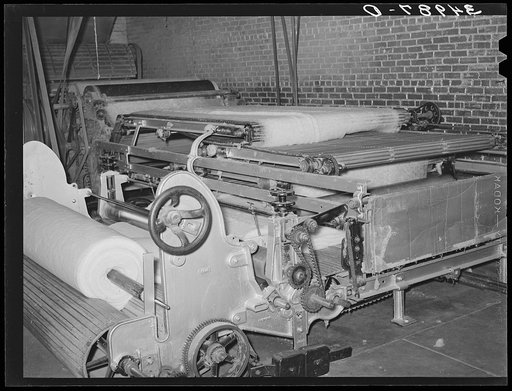Machine for making cotton bats used for filling mattresses. Mattress factory, San Angelo, Texas