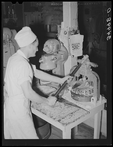 Stamping out squares of dough which will be made into rolls. Bakery, San Angelo, Texas