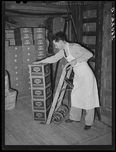Loading cartons of groceries on truck at wholesale grocery. San Angelo, Texas