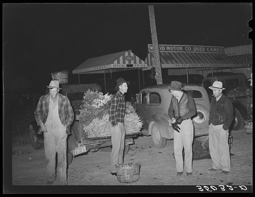 Early morning vegetable market. San Angelo, Texas. The farmers with their hands in their pockets show how cold the wind was