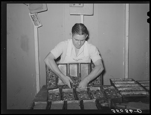 Removing fruit cakes from tin in which they were baked at bakery in San Angelo, Texas