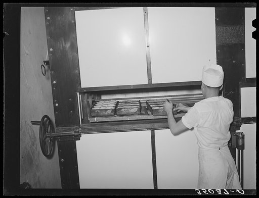 Placing rolls in reel oven to be baked. Bakery, San Angelo, Texas