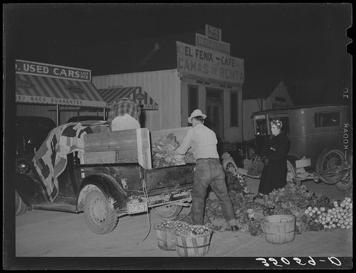Trucker and buyer at early morning farmers market. San Angelo, Texas