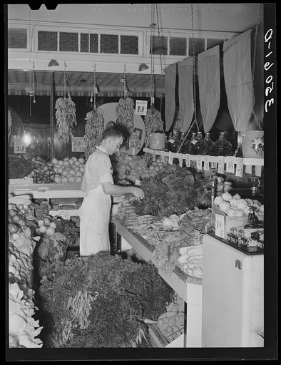 Arranging vegetables at retail grocery. San Angelo, Texas