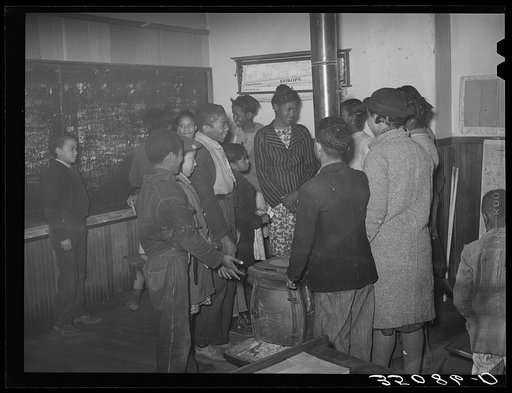 Negro children in rural school gathered around the stove as the room warms up in the morning. After school was in session the thermometer registered fifty degrees the entire morning. Creek County, Oklahoma