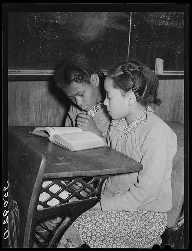 Two Negro children sitting at desk in school. Child in foreground is daughter of Pomp Hall, Negro tenant farmer. Creek County, Oklahoma. See general caption number 23