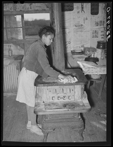 Daughter of Pomp Hall, Negro tenant farmer, cleaning off top of cook stove. Creek County, Oklahoma. See general caption number 23