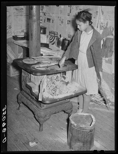 Daughter of Pomp Hall, Negro tenant farmer, taking ashes out of stove before building fire in the morning. Creek County, Oklahoma. See general caption number 23