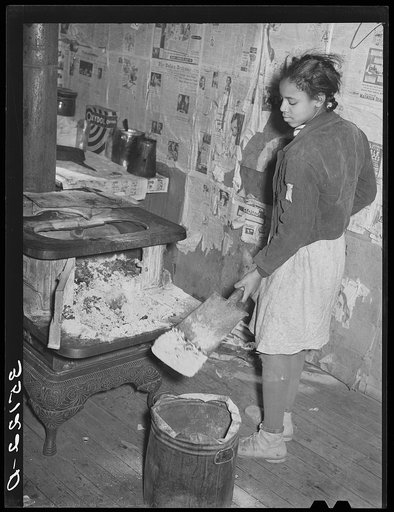 Removing ashes from stove before starting the fire in the early morning. Home of Pomp Hall, Negro tenant farmer. Creek County, Oklahoma. See general caption number 23
