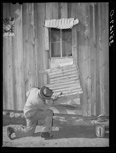 Pomp Hall, Negro tenant farmer, repairing piece of tin which covers window of his house. Creek County, Oklahoma. See general caption number 23