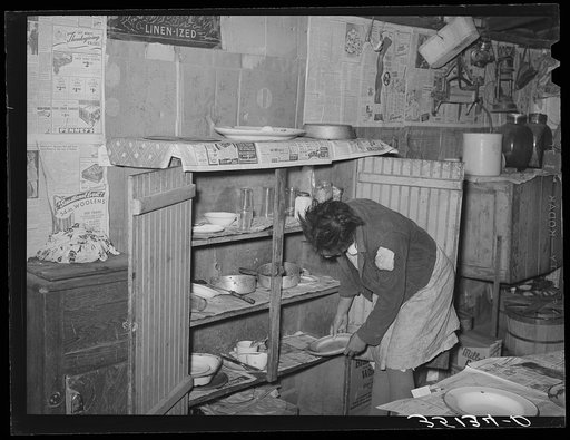 Removing plates from kitchen cupboard in home of Pomp Hall, Negro tenant farmer. Creek County, Oklahoma. See general caption number 23