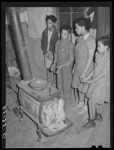 Children of Pomp Hall, Negro tenant farmer, standing by stove. Creek County, Oklahoma