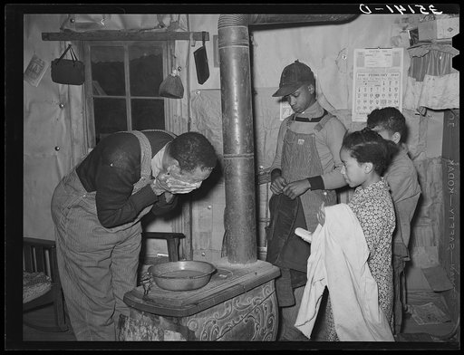 Pomp Hall, Negro tenant farmer, washing his face while his children stand by with towel and soap awaiting their turn at the washpan. Creek County, Oklahoma. See general caption number 23