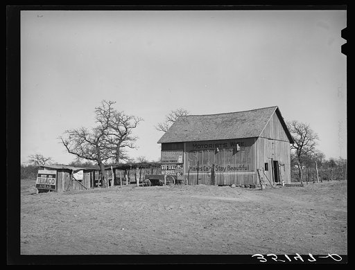 Barn and vegetable stands of Pomp Hall, Negro tenant farmer. During the summer months he sells his produce at this stand on the highway. He also adds to his income by allowing the signs to be painted on his barn which is visible far down the highway. Creek County, Oklahoma. See general caption numbe