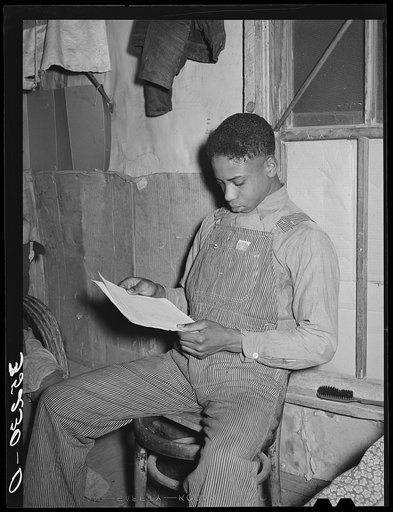 Son of Pomp Hall, Negro tenant farmer, studying price list of agricultural equipment. Creek County, Oklahoma. See general caption number 23