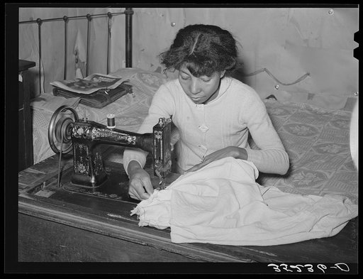 Untitled photo, possibly related to: Wife of Pomp Hall, Negro tenant farmer, threading sewing machine. She makes practically all of the clothing for her family with the exception of such things as overalls, sweaters, etc. Creek County, Oklahoma. See general caption number 23