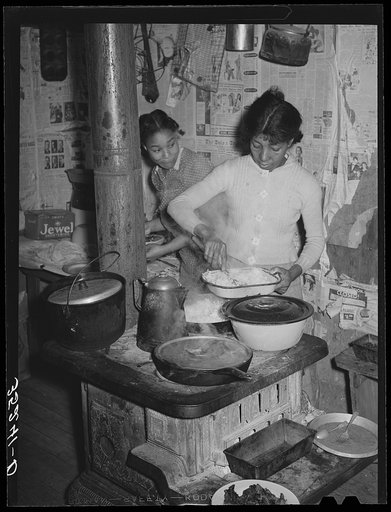 Wife and daughter of Pomp Hall, Negro tenant farmer, dishing up supper. Creek County, Oklahoma. See general caption number 23